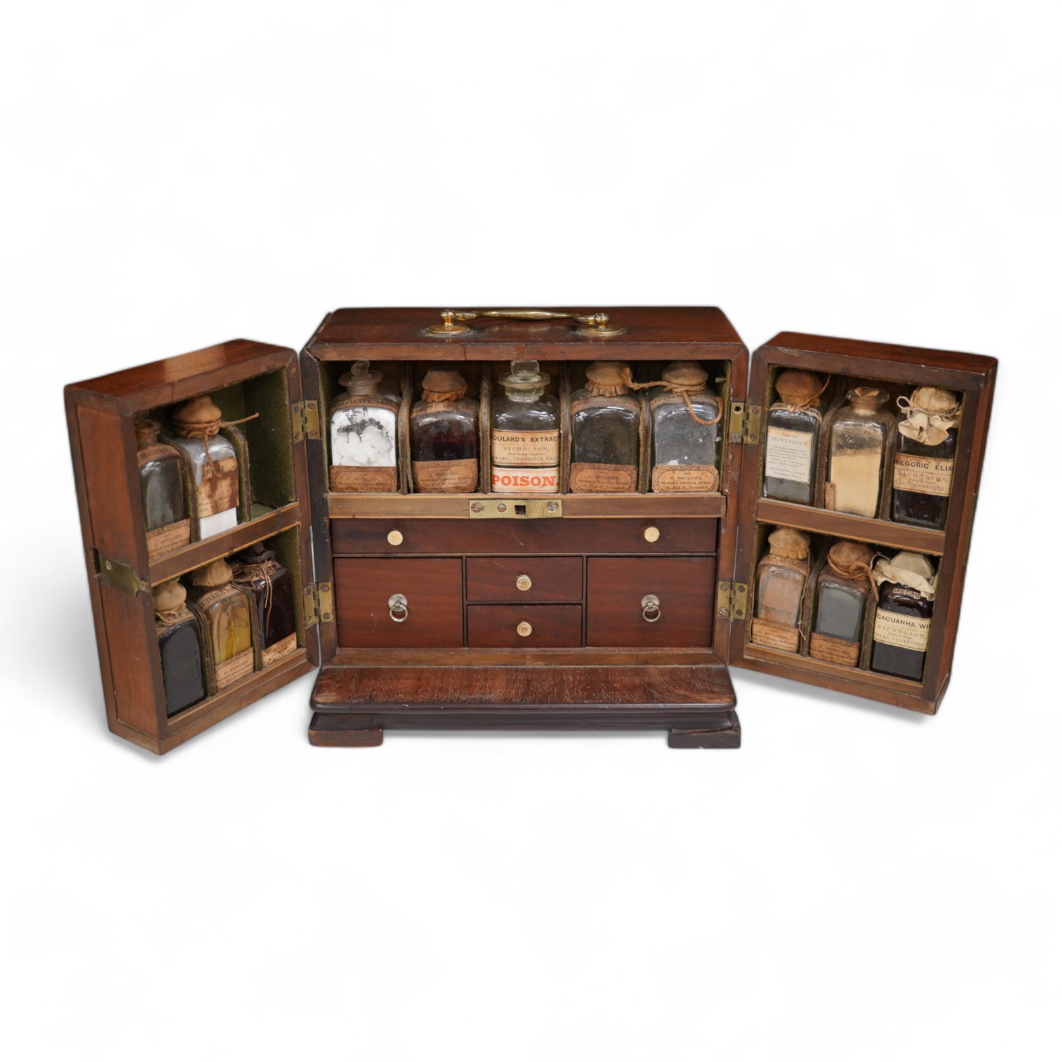 A 19th century mahogany apothecary cabinet, containing 20 bottles of various medicinal compounds and poisons, some sealed, all with paper labels, mainly for ‘C. Woollven, Operative & Dispensing Chemist, 108, High Street,